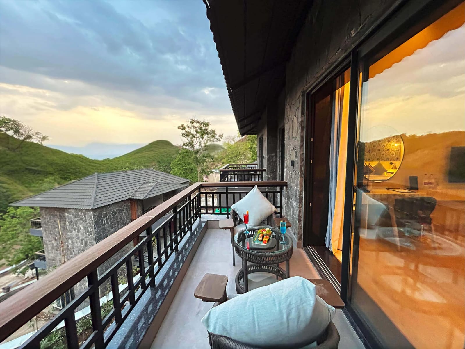 Private resort balcony at sunset with Aravalli hill views