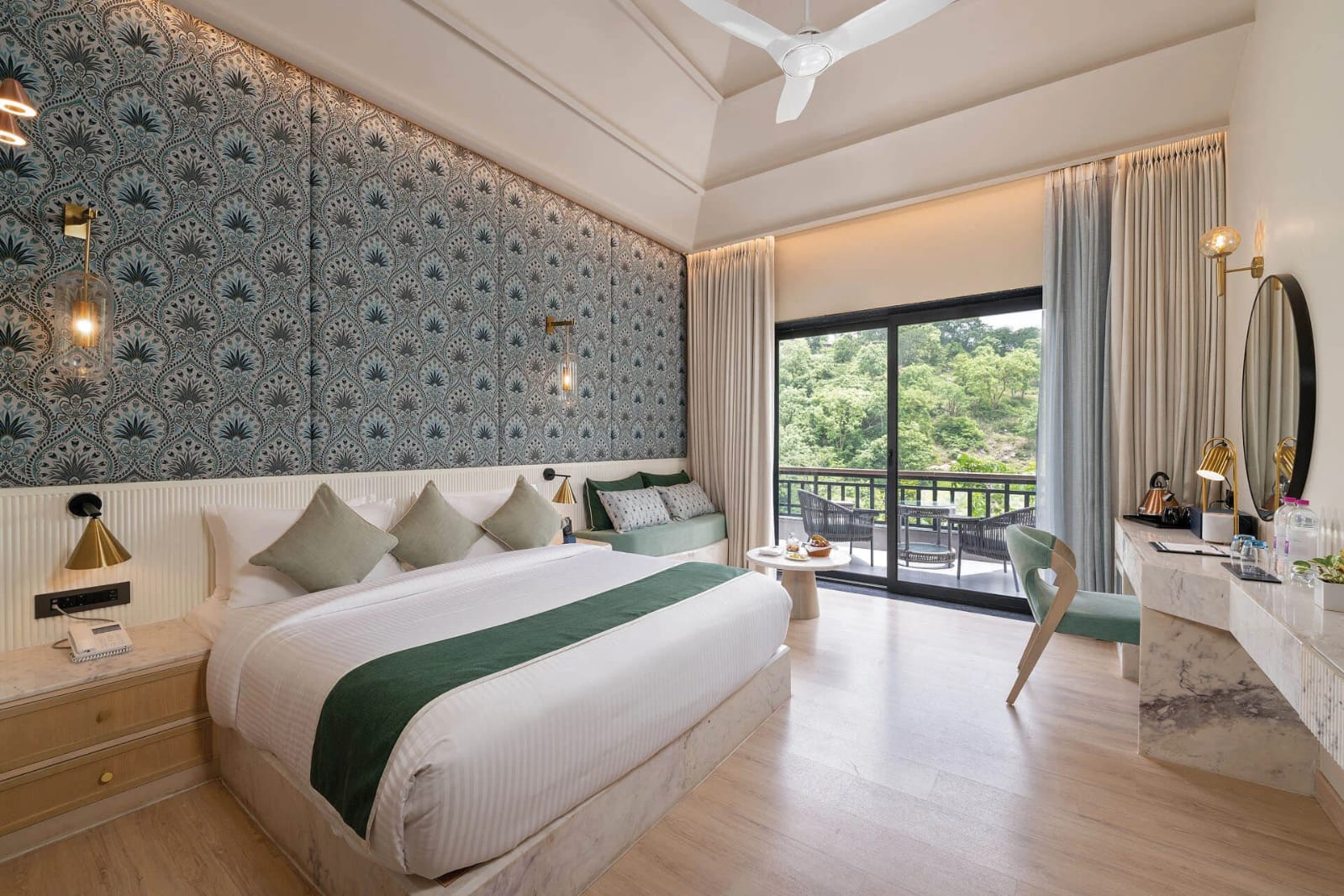 Deluxe king room with peacock-motif wallpaper and balcony at a Kumbhalgarh resort